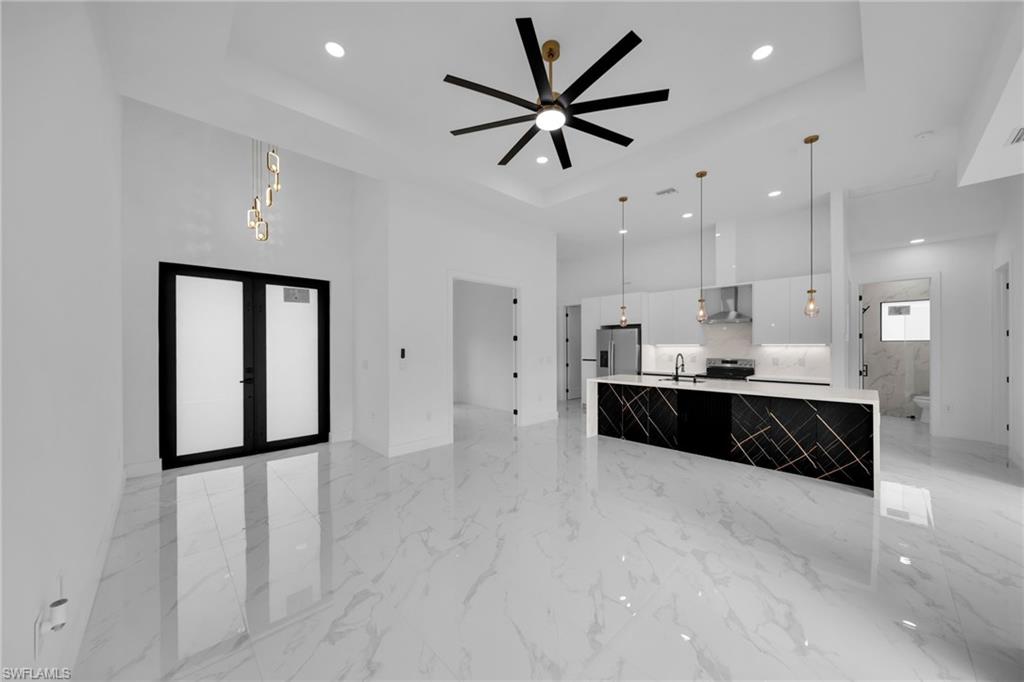 1138 Garibaldi Street East Lehigh Acres, FL 33974 - Photo 36 of 36 Kitchen featuring decorative light fixtures, a spacious island, open floor plan, light marble finish floors, and a high ceiling
