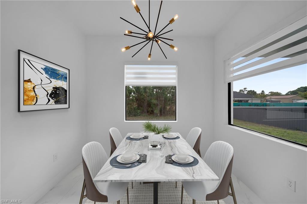 1138 Garibaldi Street East Lehigh Acres, FL 33974 - Photo 12 of 36 Dining room with marble look tile flooring, plenty of natural light, and a chandelier