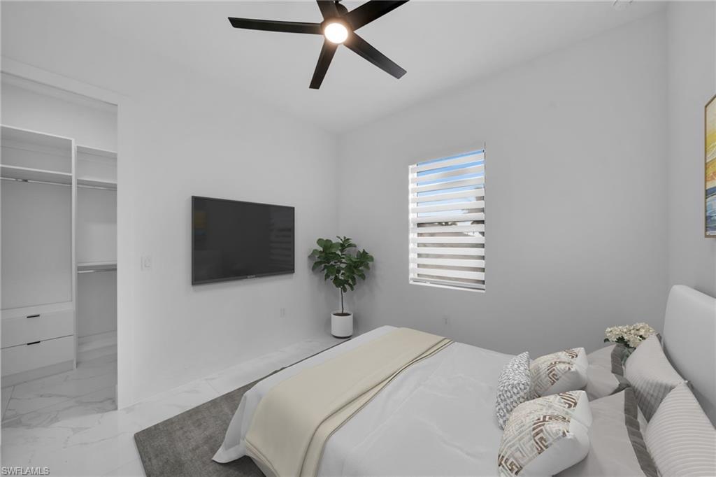 1138 Garibaldi Street East Lehigh Acres, FL 33974 - Photo 26 of 36 Bedroom featuring a walk in closet, light marble finish floors, and a ceiling fan