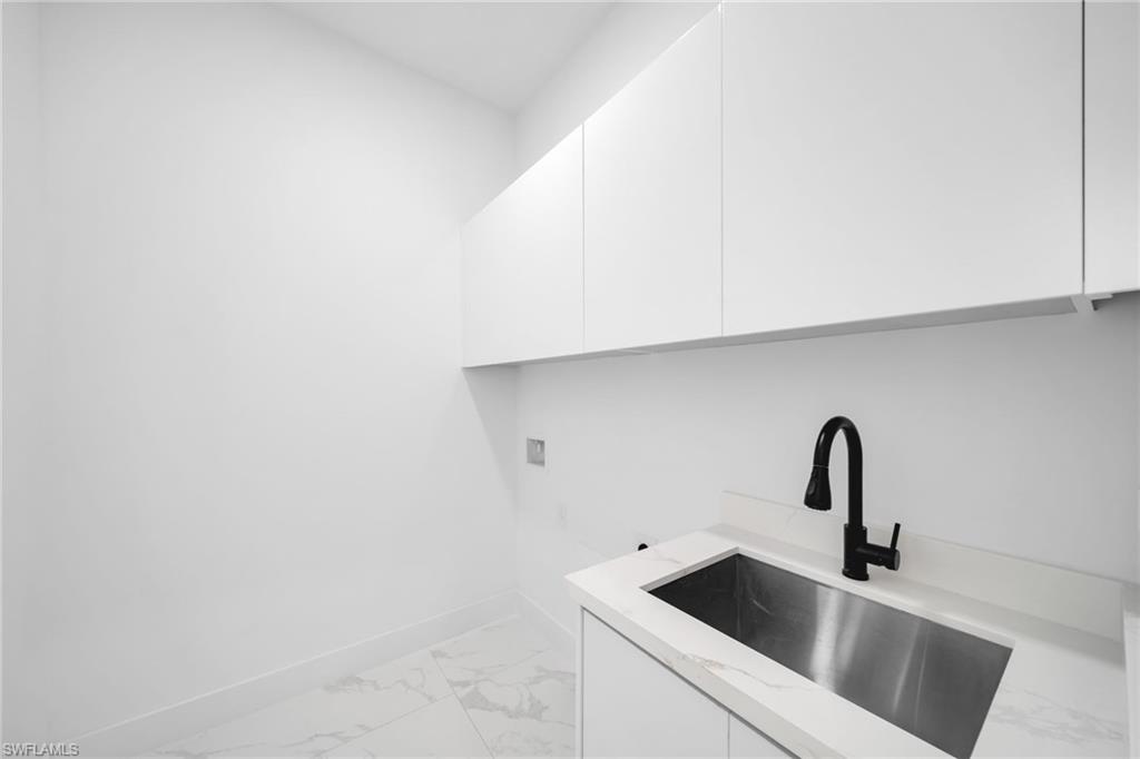 1138 Garibaldi Street East Lehigh Acres, FL 33974 - Photo 29 of 36 Laundry area featuring light marble finish floors, cabinet space, and washer hookup