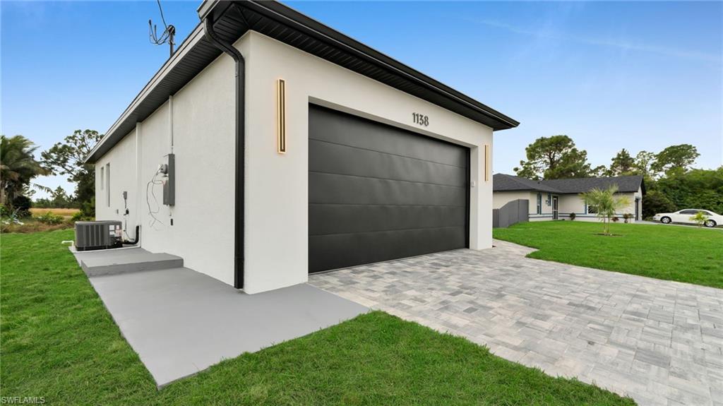 1138 Garibaldi Street East Lehigh Acres, FL 33974 - Photo 3 of 36 Garage featuring decorative driveway