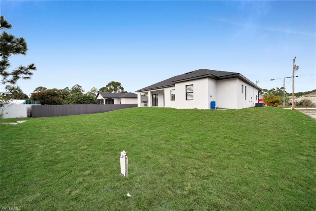 1138 Garibaldi Street East Lehigh Acres, FL 33974 - Photo 34 of 36 Rear view of house featuring stucco siding and a patio