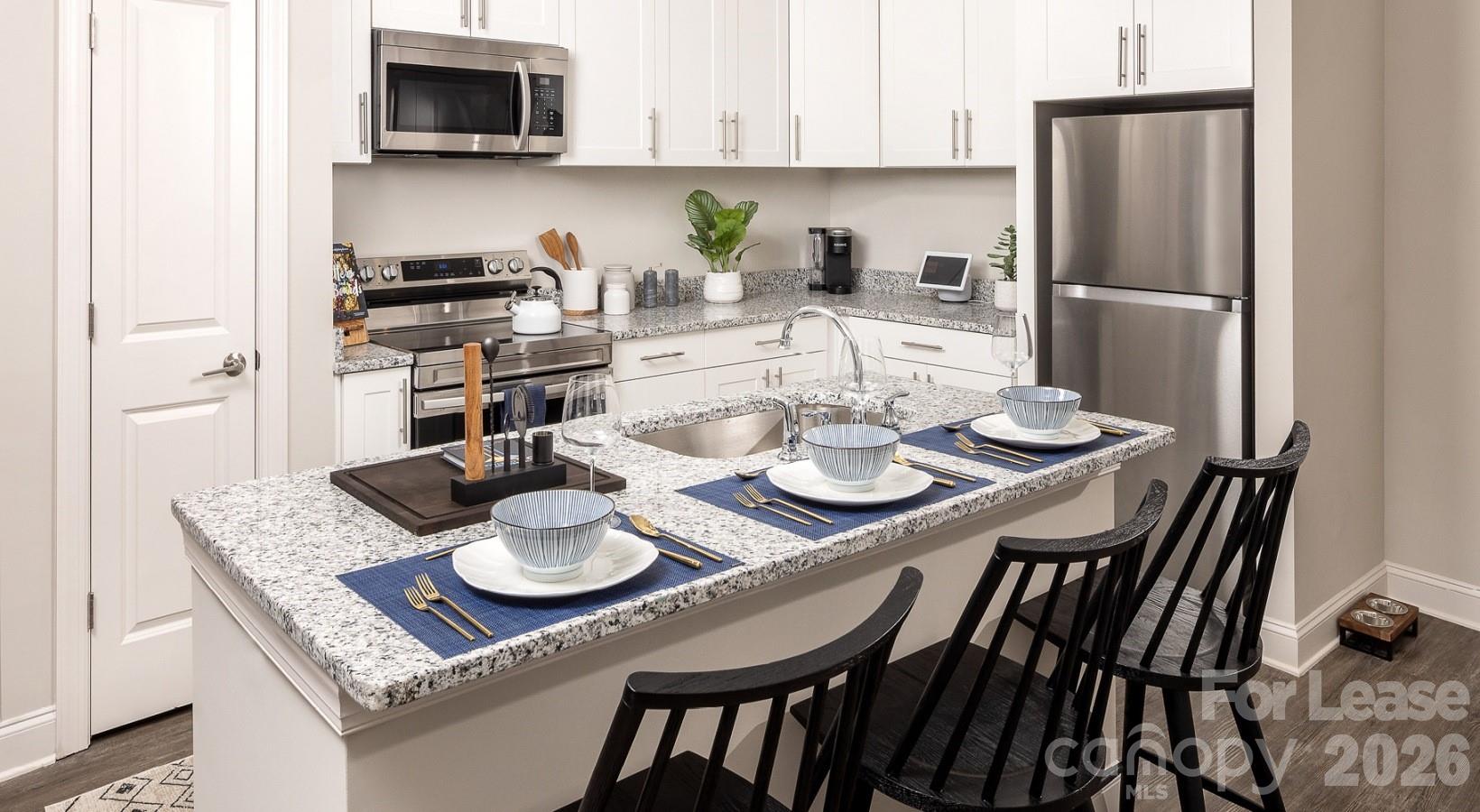 8424 North Tryon Street, Unit A2 Charlotte, NC 28262 - Photo 17 of 25 a kitchen with a table and chairs in it