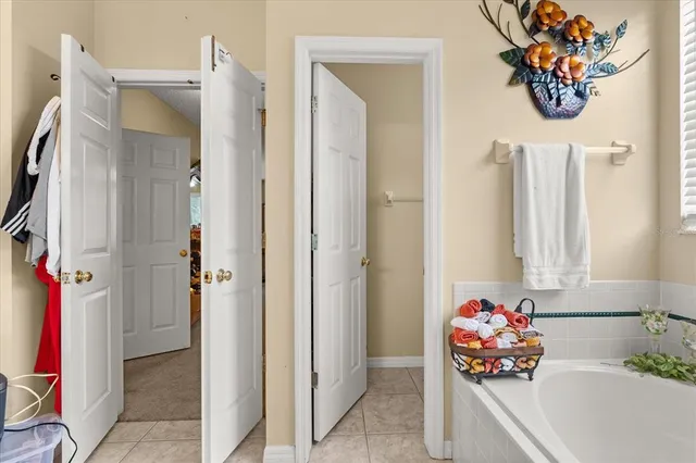 a bedroom with a bed chandelier and a window