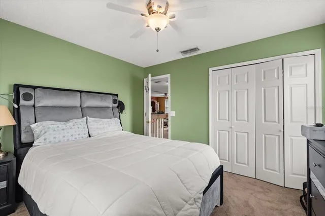 a bedroom with a bed a desk and chair with the potted plants