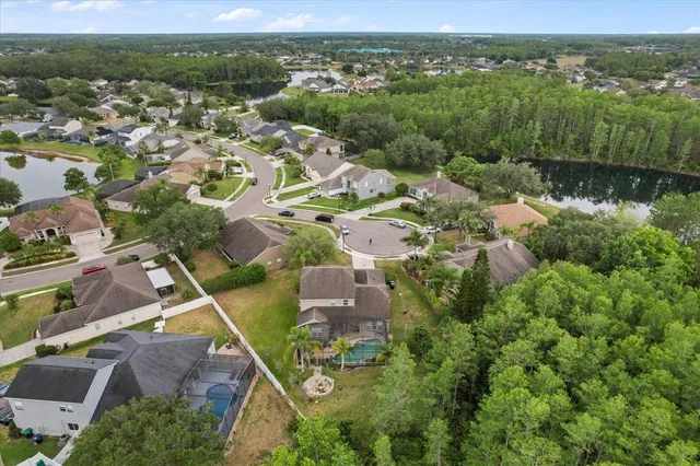 an empty room with chandelier fan and windows