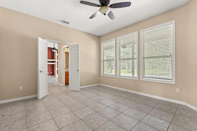 a bedroom with window and a ceiling fan