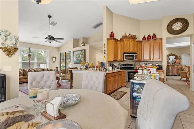 a living room with furniture kitchen view and a chandelier