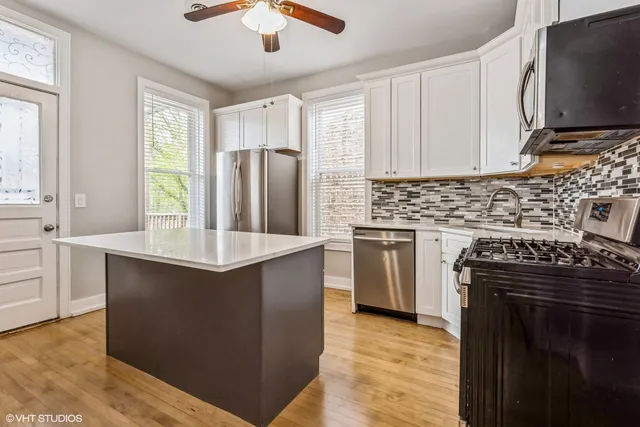 a kitchen with stainless steel appliances granite countertop a stove a sink and a refrigerator