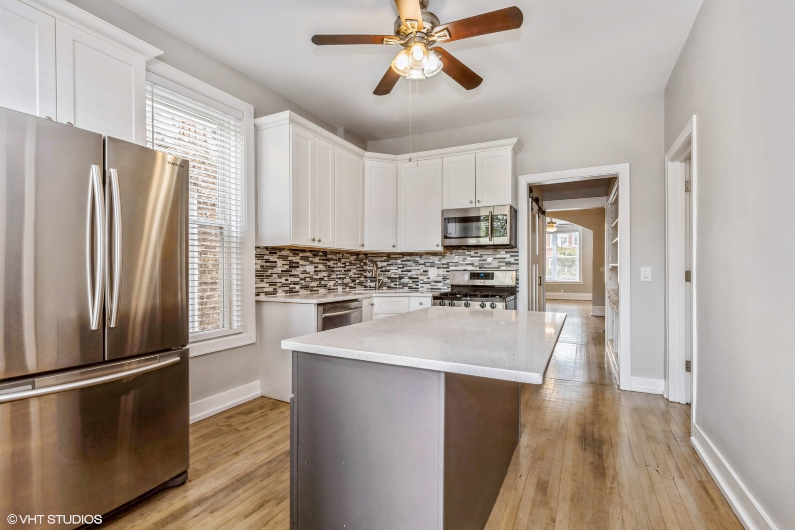 2622 West Crystal Street, Unit 2 Chicago, IL 60622 - Photo 6 of 10 a kitchen with kitchen island a counter top space wooden floor and stainless steel appliances