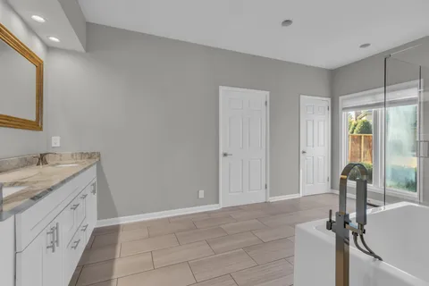 a bathroom with a granite countertop sink vanity and mirror