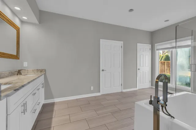 a bathroom with a granite countertop sink vanity and mirror
