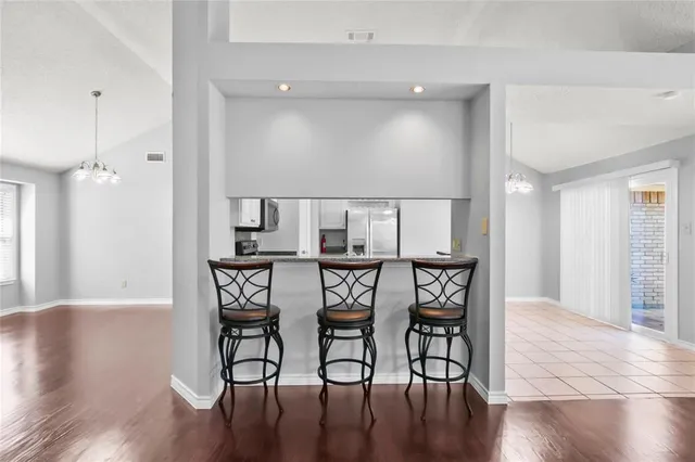 a view of a livingroom with fireplace wooden floor and a chandelier