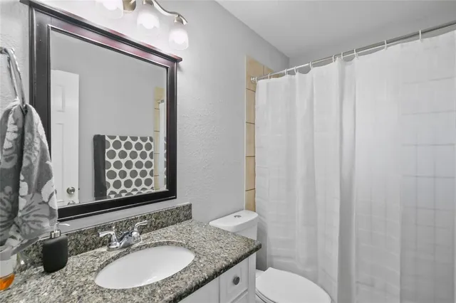 an empty room with wooden floor ceiling fan and windows