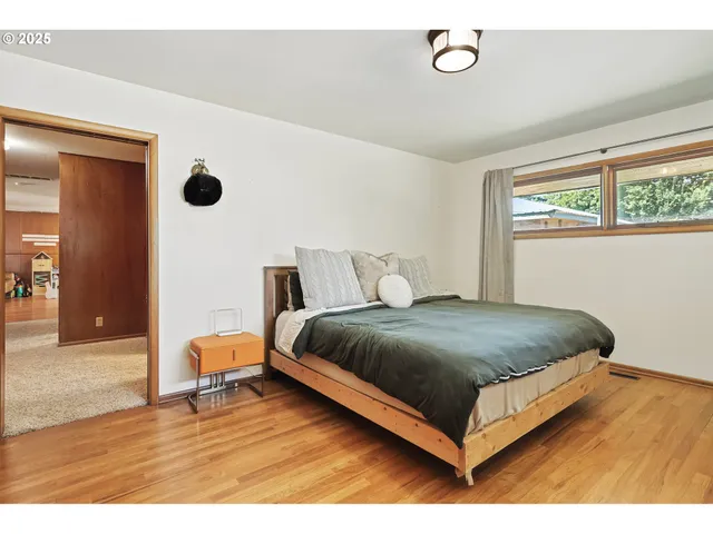 a bedroom with a bed lamp and a large window