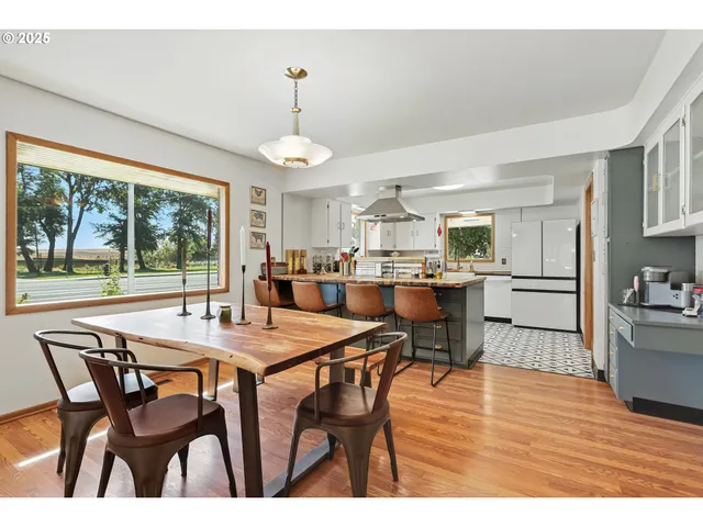 a open dining room with stainless steel appliances kitchen island a table chairs and chandelier