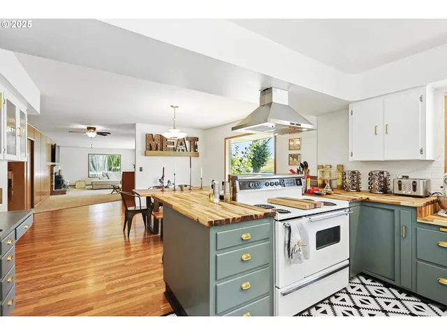a kitchen that has a lot of cabinets in it and wooden floors