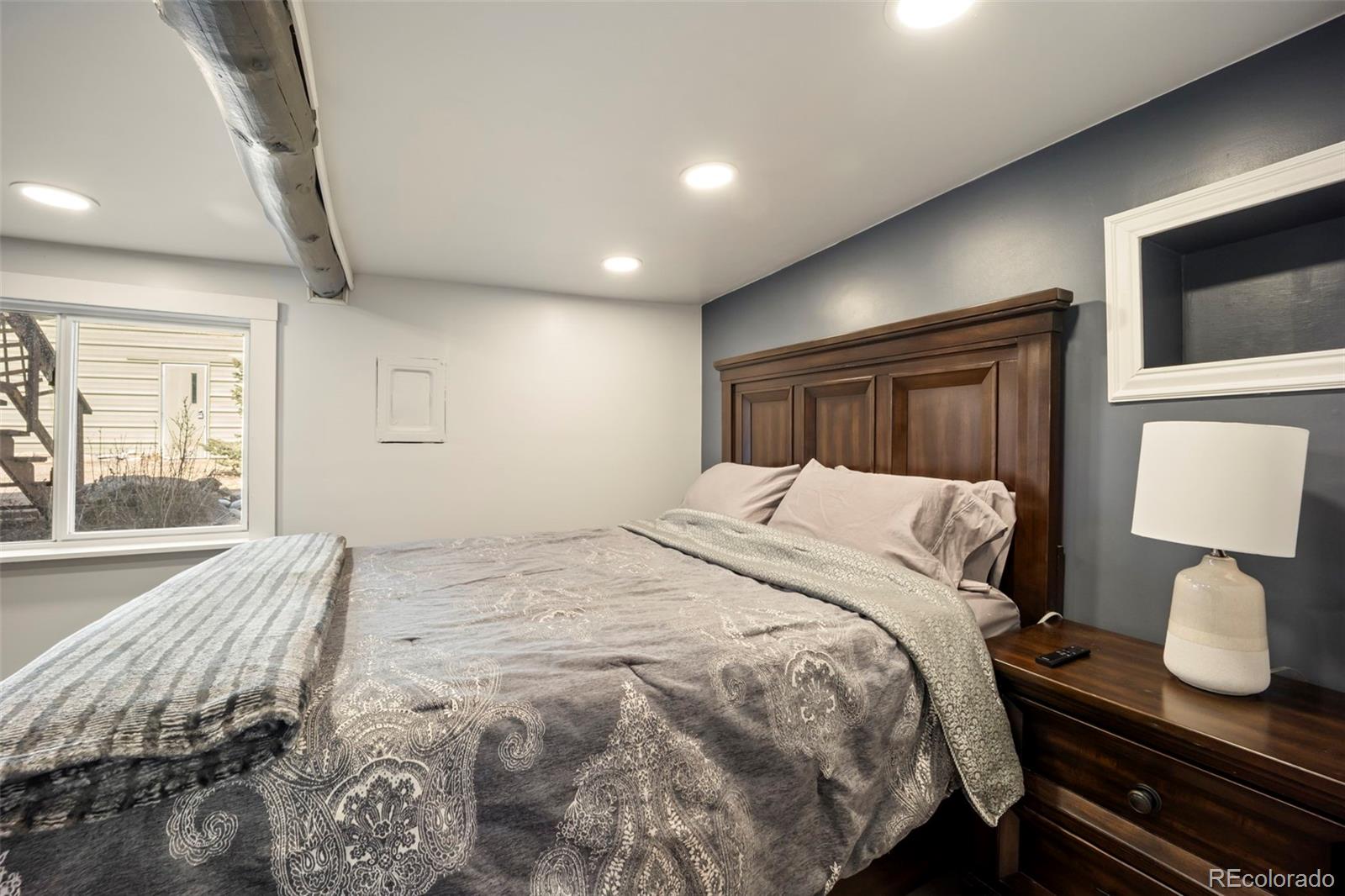 25874 Mosier Street Conifer, CO 80433 - Photo 14 of 45 a bedroom with a bed and wooden floor
