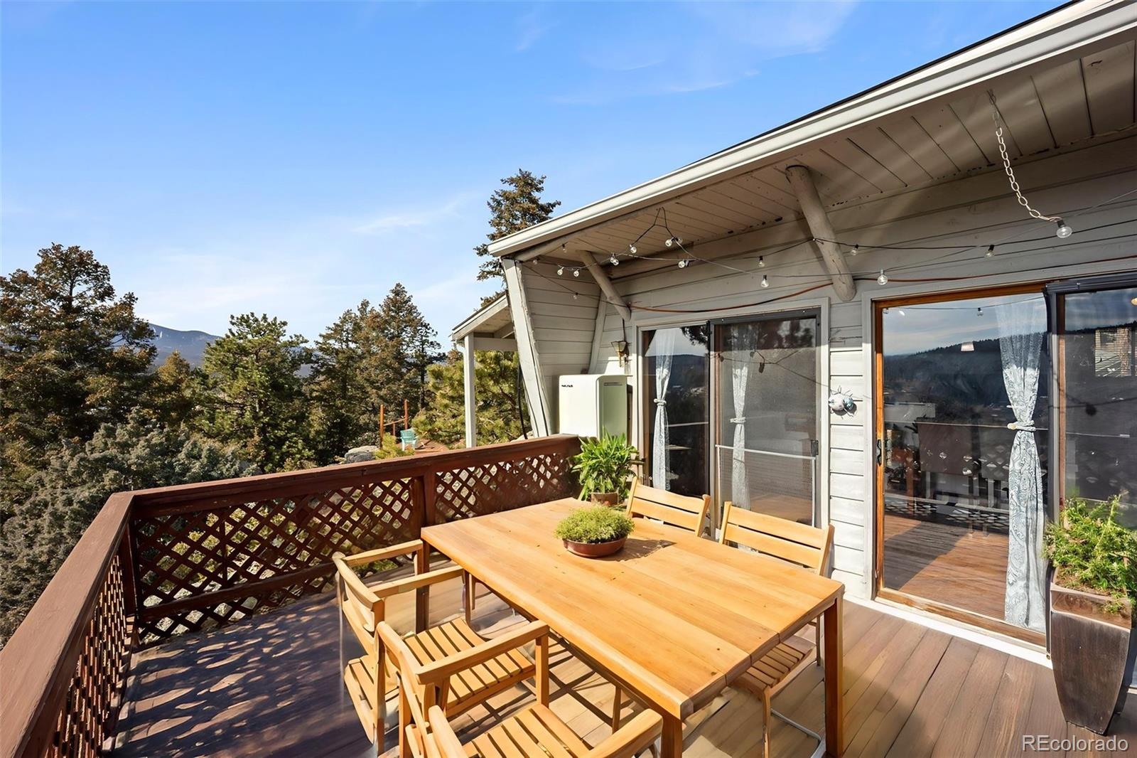 25874 Mosier Street Conifer, CO 80433 - Photo 19 of 45 a view of a patio with table and chairs with wooden floor and fence