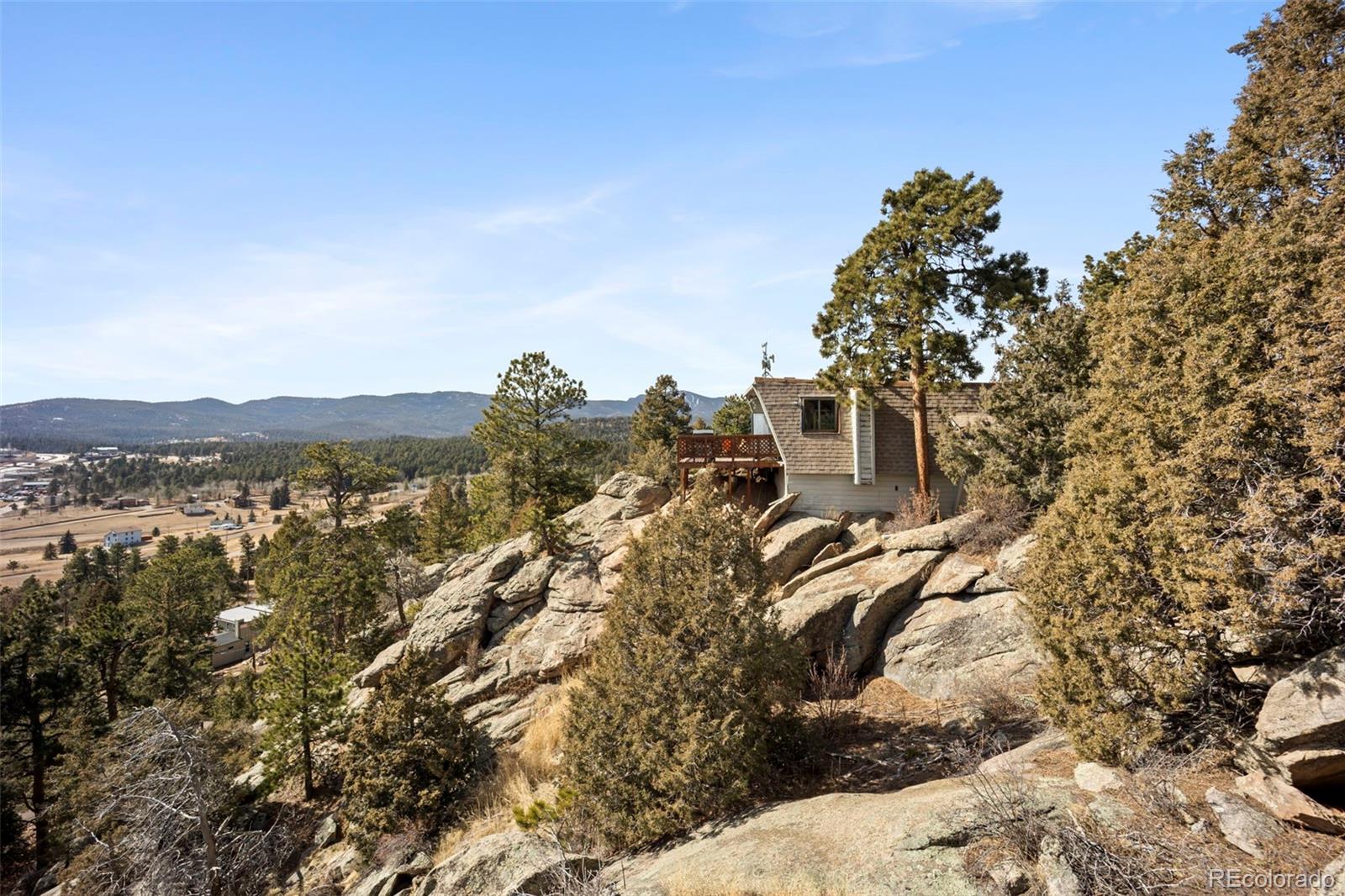 25874 Mosier Street Conifer, CO 80433 - Photo 26 of 45 a view of a forest with a building in the background