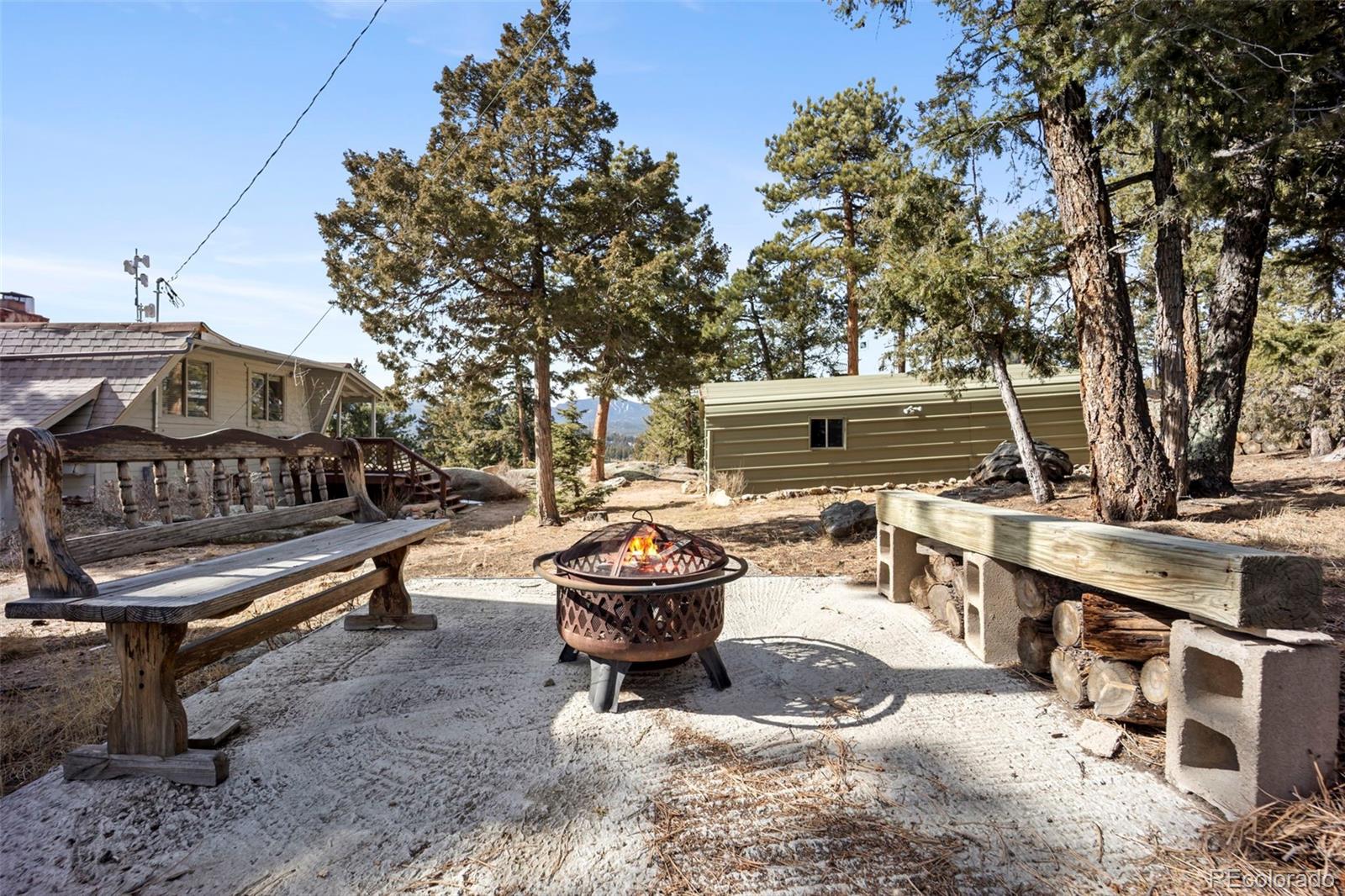 25874 Mosier Street Conifer, CO 80433 - Photo 27 of 45 a backyard of a house with barbeque oven and outdoor seating