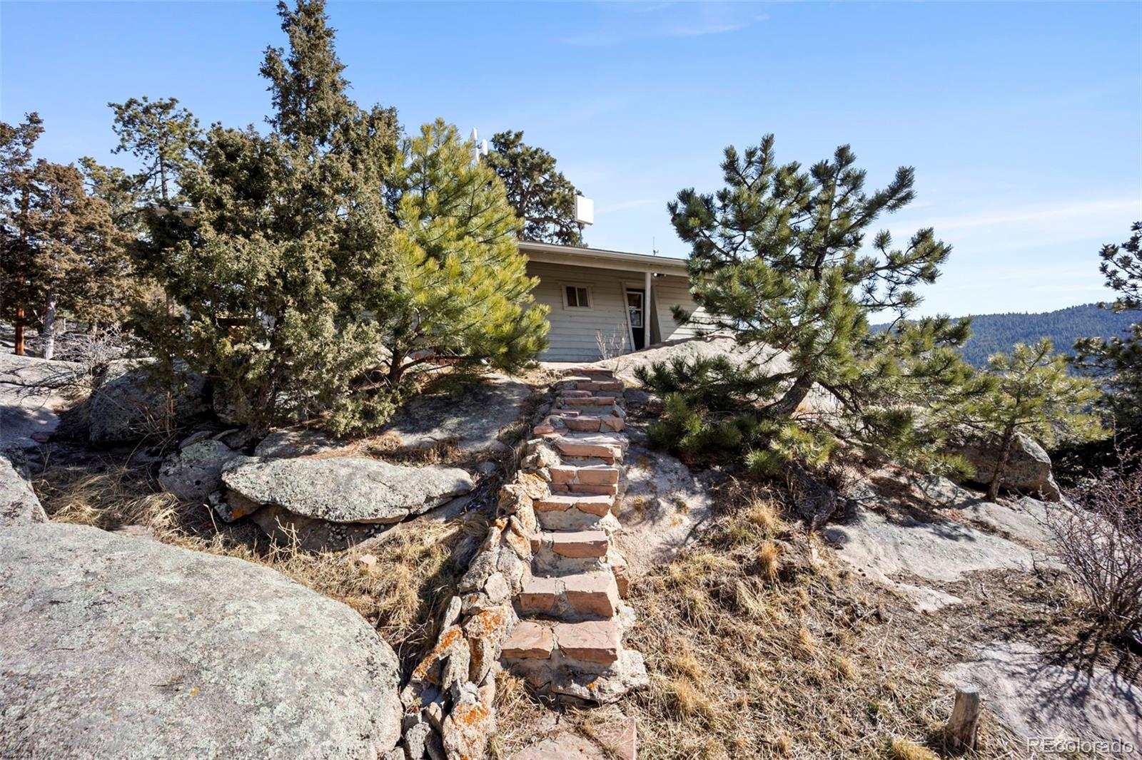 25874 Mosier Street Conifer, CO 80433 - Photo 32 of 45 a view of a house with a yard and covered with trees