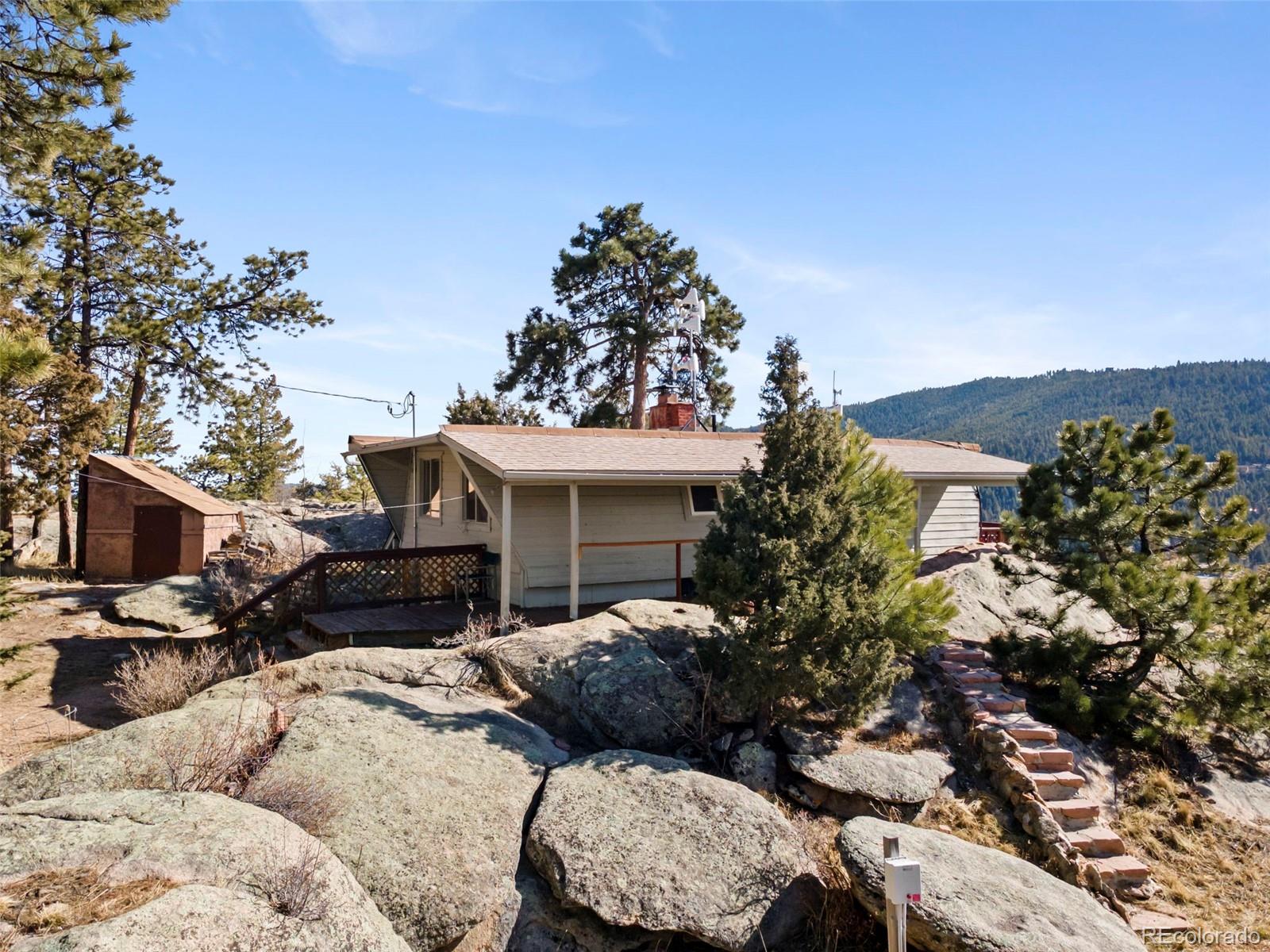 25874 Mosier Street Conifer, CO 80433 - Photo 36 of 45 a backyard of a house with a garden and outdoor seating