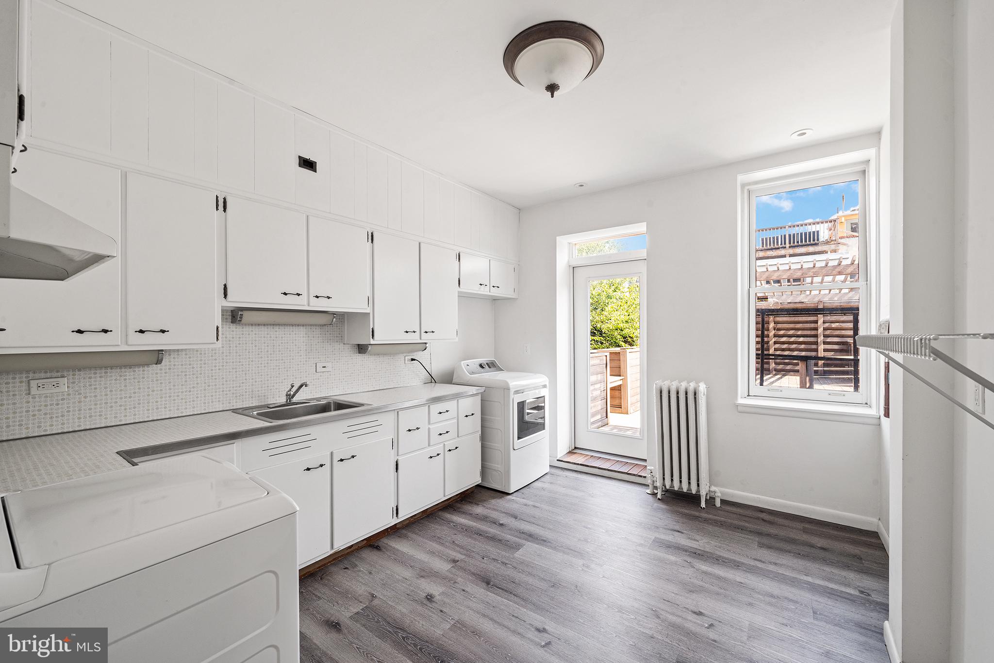 231 Pine Street, Unit 2 Philadelphia, PA 19106 - Photo 10 of 23 a kitchen with a white cabinets and wooden floor