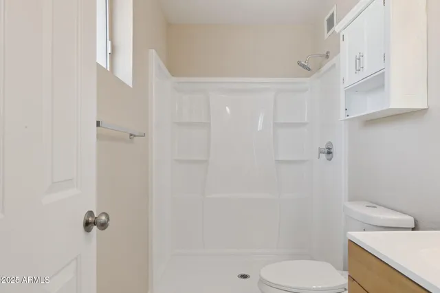 a bathroom with a toilet and a shower