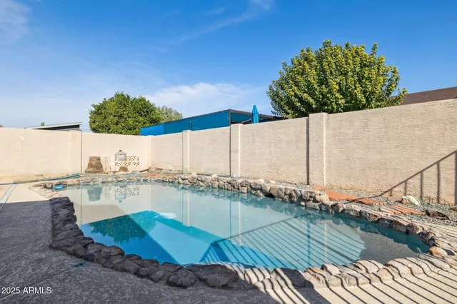 a swimming pool with outdoor seating and yard