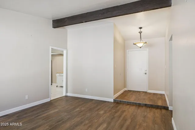 an empty room with wooden floor and cabinet