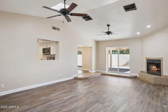 a view of an empty room with a window and a fireplace