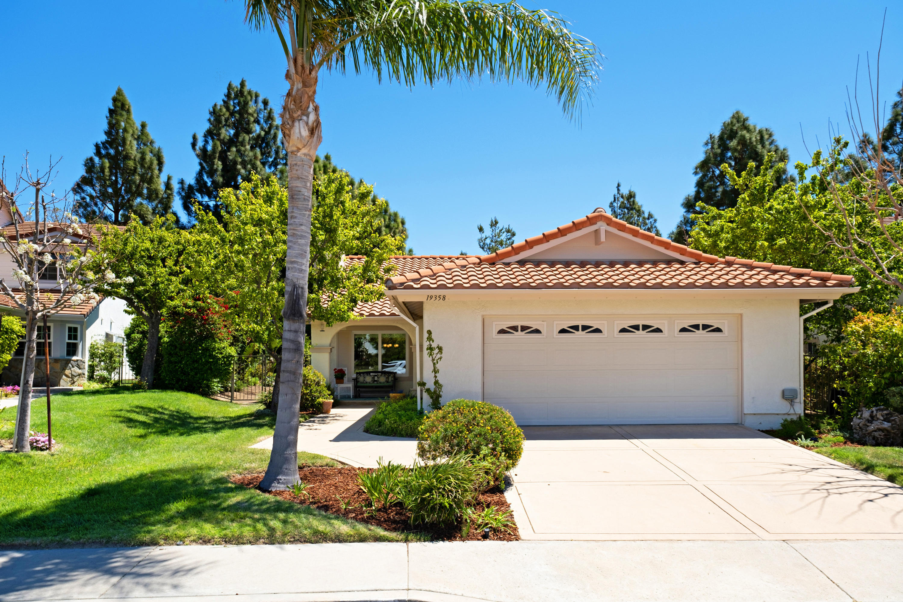 19358 Crystal Ridge Lane Porter Ranch, CA 91326 - Photo 1 of 37 a view of a white house with a yard and palm trees