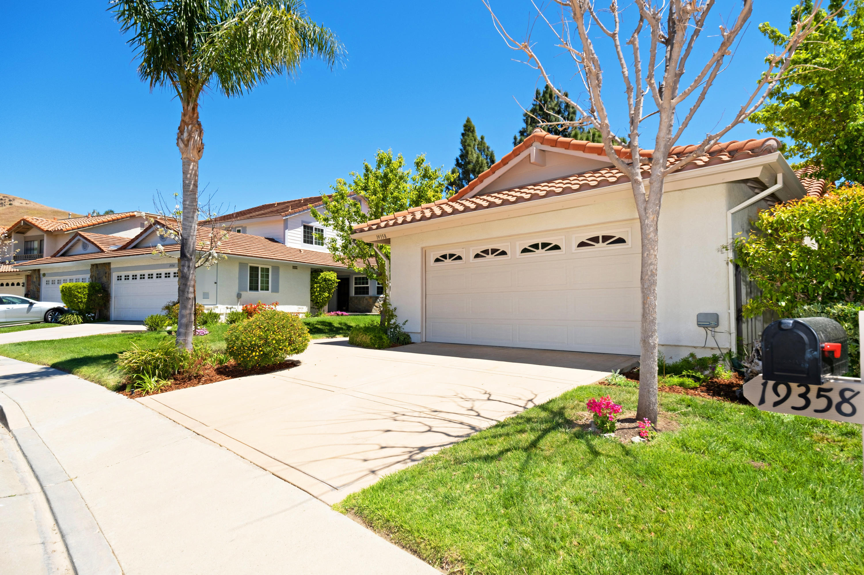 19358 Crystal Ridge Lane Porter Ranch, CA 91326 - Photo 4 of 37 a front view of a house with a yard and garage