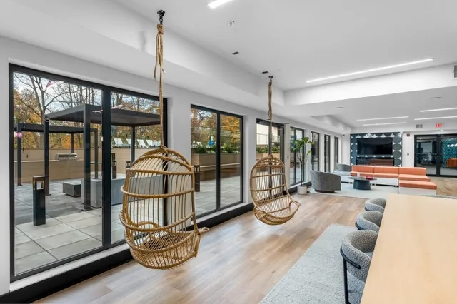 a living room with furniture a floor to ceiling window and floor to ceiling window