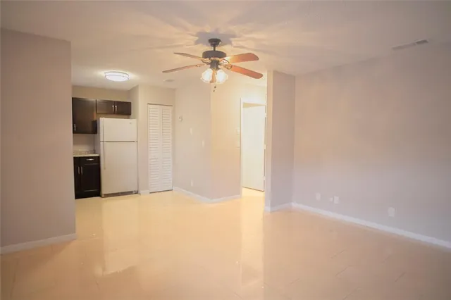 a view of a kitchen with a sink and a refrigerator