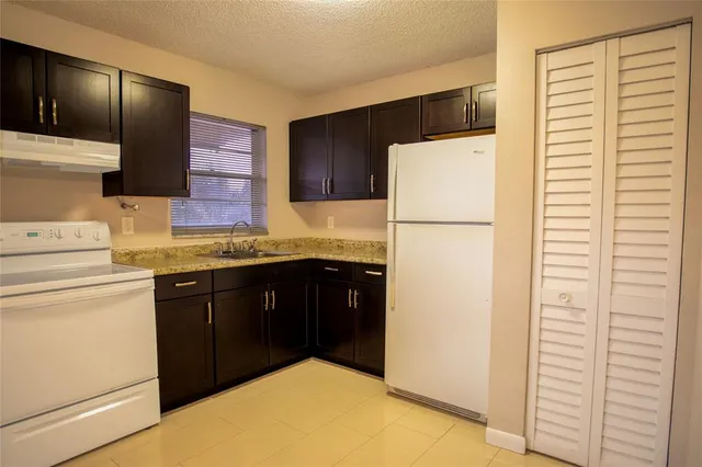 a kitchen with a refrigerator sink and cabinets