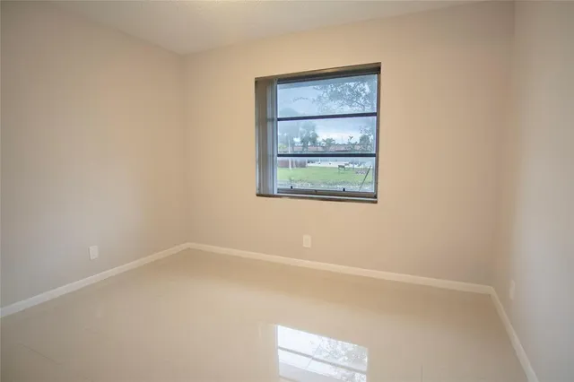 an empty room with closet and windows