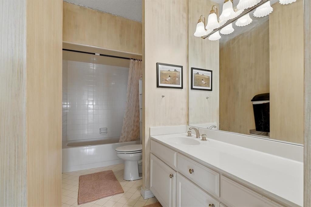 5200 Keller Springs Road, Unit 1315 Dallas, TX 75248 - Photo 11 of 40 a bathroom with a sink a toilet and a large mirror