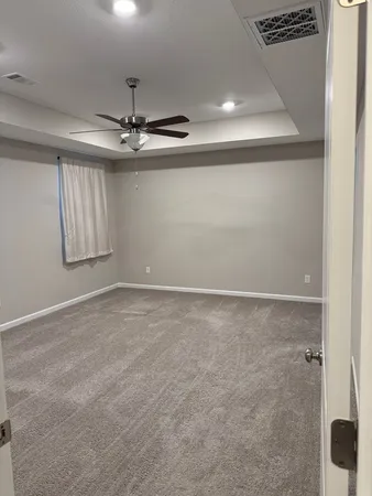 an empty room with windows and fan