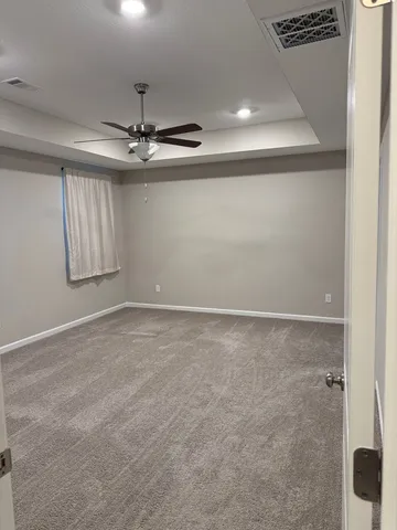 an empty room with windows and fan