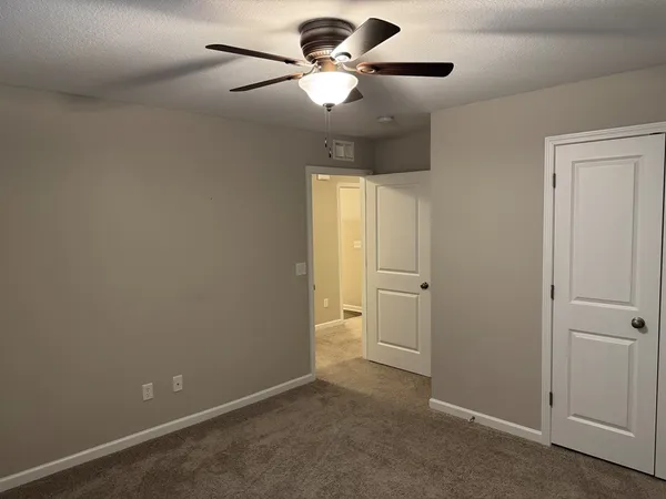 a view of an empty room and a ceiling fan