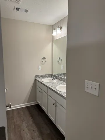 a bathroom with a granite countertop sink and a mirror