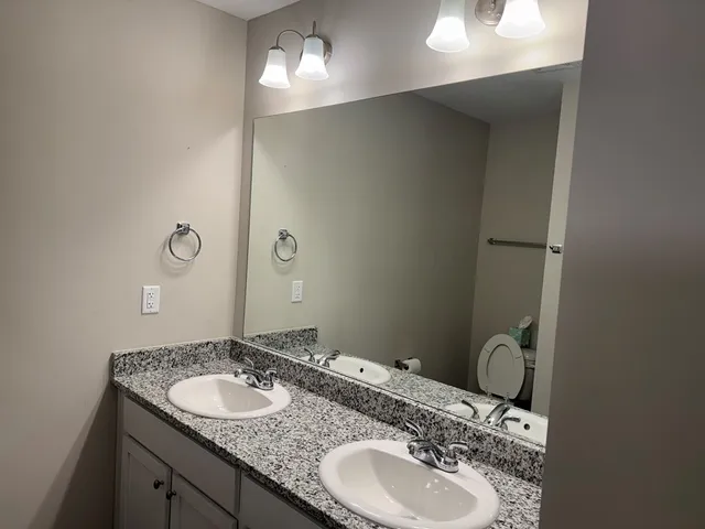 a bathroom with a granite countertop sink and a mirror