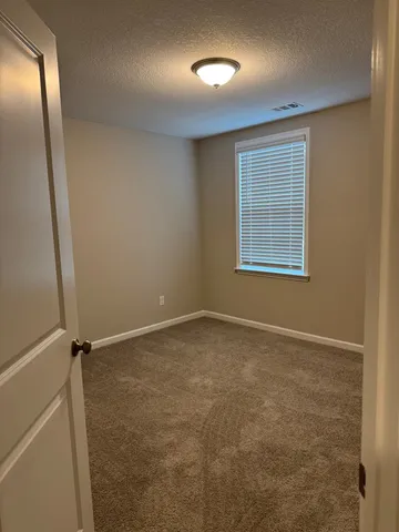 an empty room with windows and closet