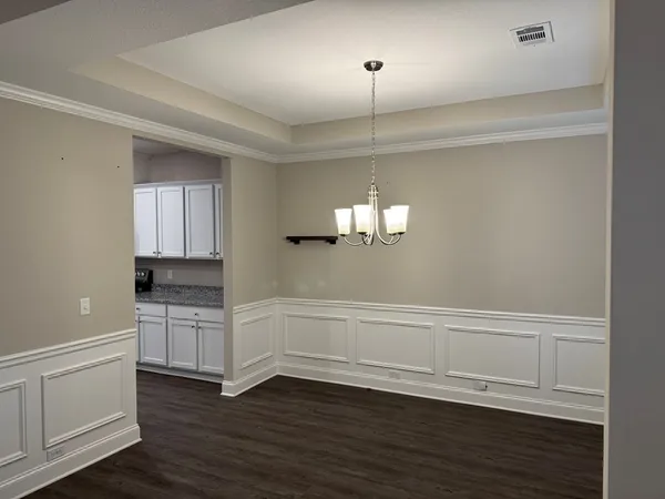 an empty room with wooden floor sink and cabinet