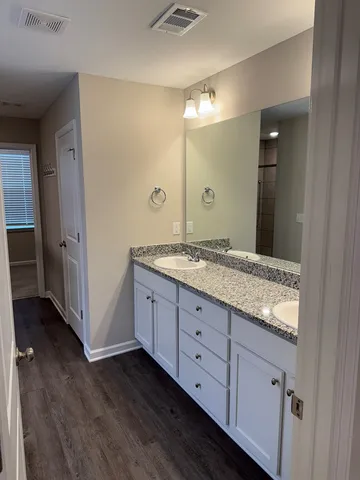a bathroom with a granite countertop sink mirror and shower