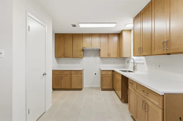 a kitchen with cabinets and wooden floor