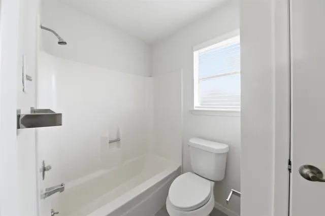 a white toilet sitting next to a bath tub