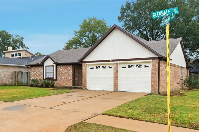 a view of a white house with a yard and garage